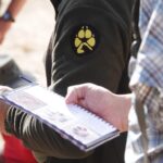 Deelnemers met een informatieschrift die meedoen aan een Workshop Wolvensporen gegeven door Weylin Tracking.